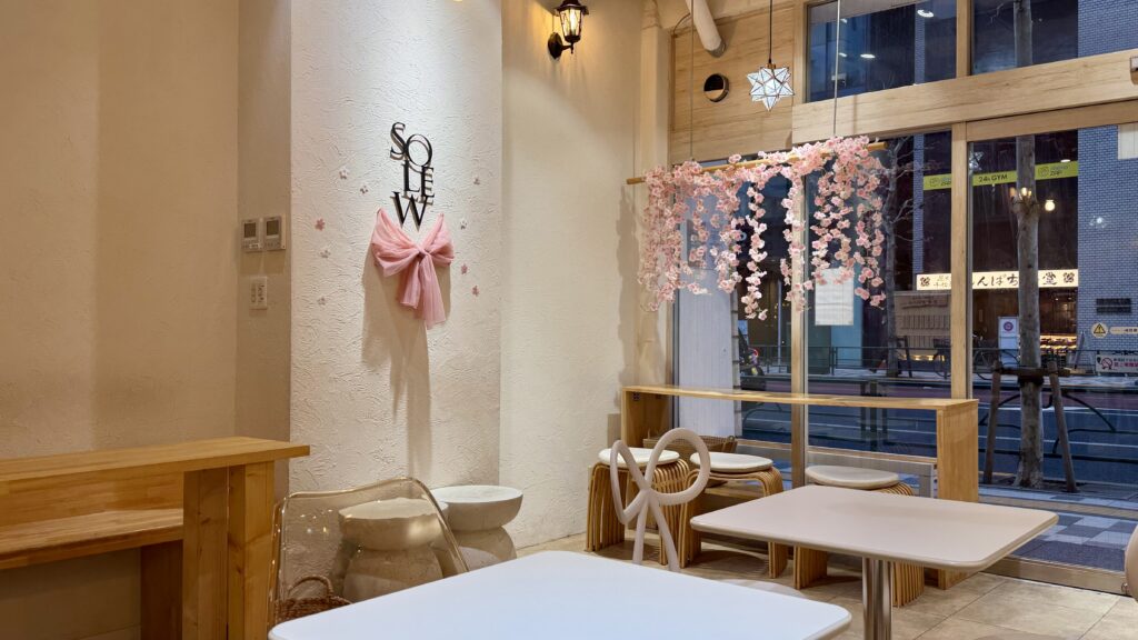 Solewの店内にあるロゴの横にピンクのリボンが飾られ、窓辺には桜の造花が垂れ下がり春の装飾が施されている